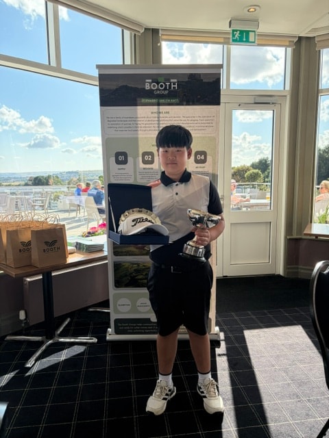 Junior golfer with trophy and prize at the Booth Group stand