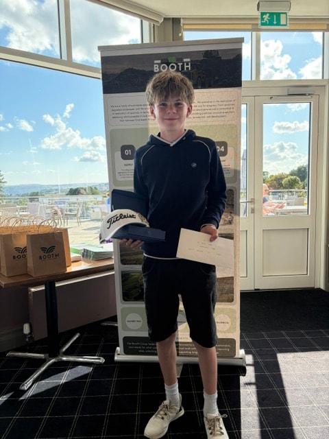 Junior golfer with salver and prize at the Booth Group stand