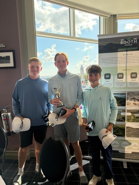 Junior golfer with trophy and prize at the Booth Group stand